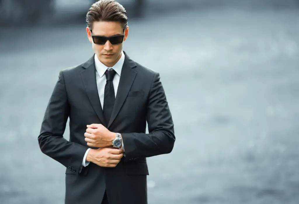 男人穿着黑色西装，配上手表——时髦的男士配饰